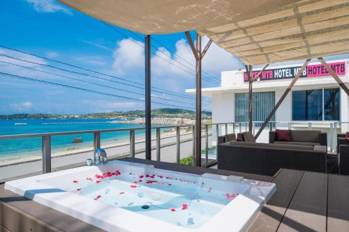 bañera de hidromasaje en el balcón con vistas a la playa en HOTEL MTB, en Motobu