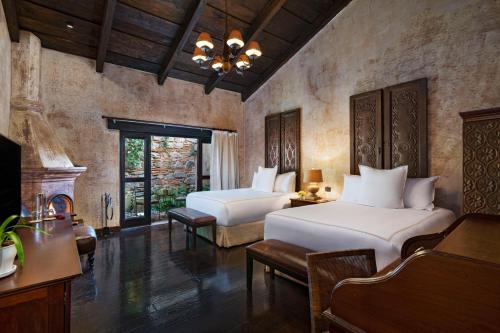a bedroom with two beds and a fireplace at El Convento Boutique Hotel in Antigua Guatemala