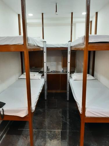 three bunk beds in a room with a kitchen at BAY INN in Chennai