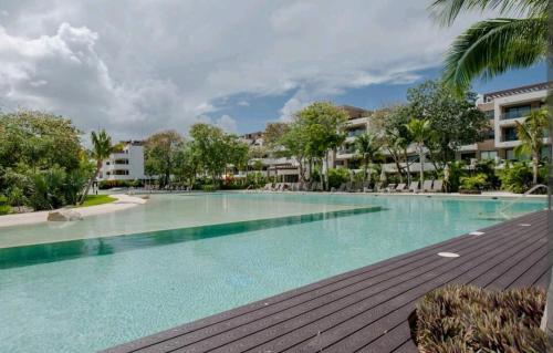 - une grande piscine dans un complexe avec des arbres et des bâtiments dans l'établissement CondoHotel En Riviera Maya, Playa del Carmen, à Playa del Carmen