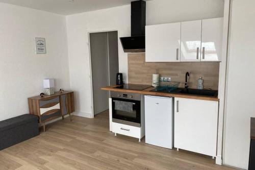 une cuisine avec des armoires blanches et un plancher en bois dans l'établissement Studio des Arts - Centre ville, à Thonon-les-Bains