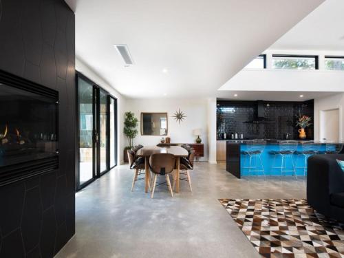 a kitchen and dining room with a table and blue cabinets at Arenas South- 3 bedroom, 2 bathroom home in Daylesford