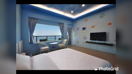 une chambre avec un grand lit et une télévision dans l'établissement 夏之嶼海景包棟民宿, à Île Lamay