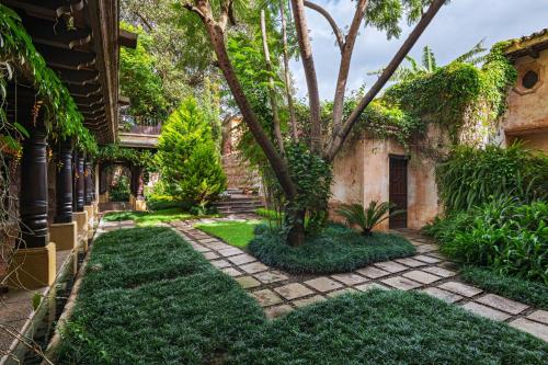 a garden with grass and trees next to a building at El Convento Boutique Hotel in Antigua Guatemala