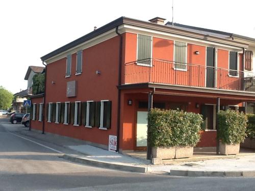 a red building on the side of a street at Locanda Gallo in Dolo