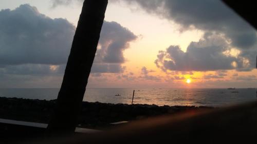 a sunset from a beach with the ocean in the background at Mermaid Island Beach Resorts in Puducherry