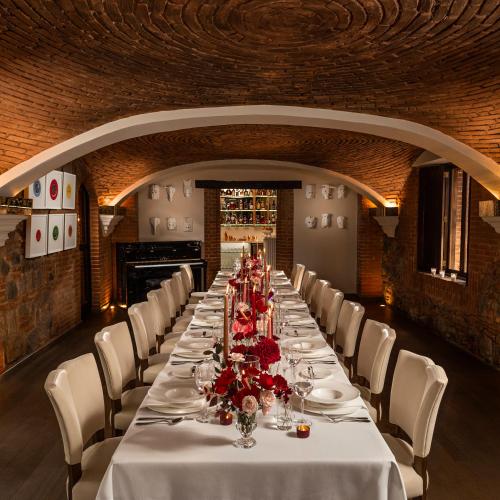 a long dining room with a long table with white chairs at El Convento Boutique Hotel in Antigua Guatemala