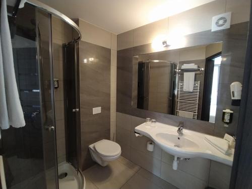 a bathroom with a toilet and a sink and a shower at Hotel Soray in Wieliczka