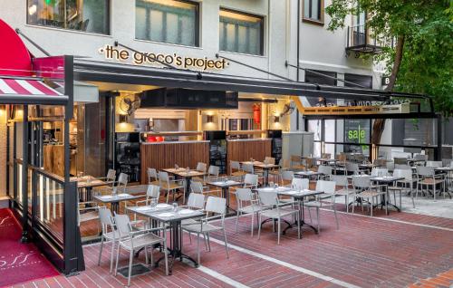 a restaurant with tables and chairs in front of a building at Athenian Foss in Athens