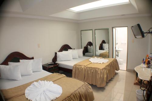Habitación de hotel con 2 camas y espejo en Hotel Business, en Bogotá