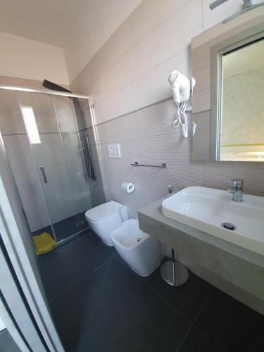 Un baño con lavabo, inodoro y ducha. en Evergreen B&B, en Porto Cesareo