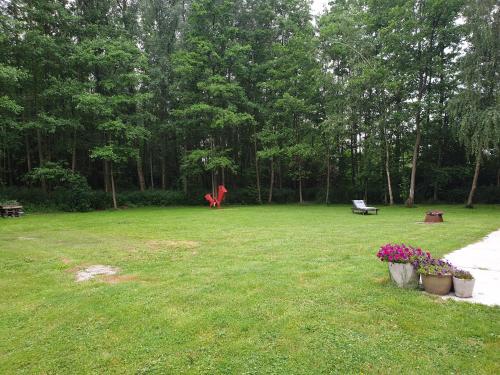a park with a bench and flowers in the grass at Eden in Sint-Pauwels
