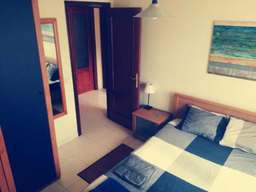 a bedroom with a bed and a table and a mirror at La Casita de la Playa in Suances