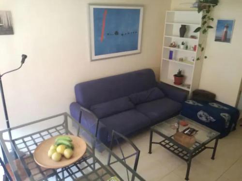 a living room with a blue couch and a table at La Casita de la Playa in Suances