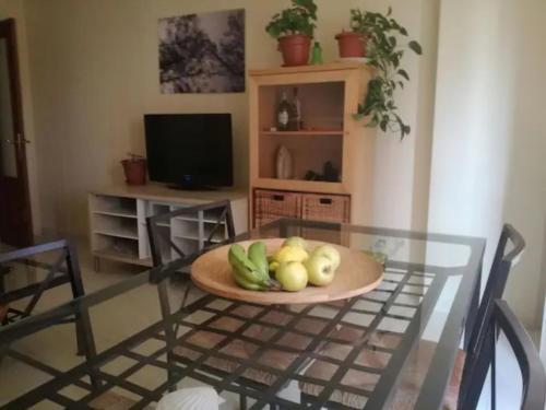 a glass table with a bowl of fruit on it at La Casita de la Playa in Suances