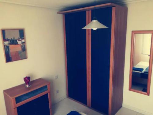 a room with a blue wall and a mirror at La Casita de la Playa in Suances
