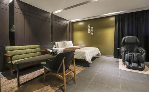 a hotel room with a bed and a chair at Hotel Banwol Asiad in Incheon