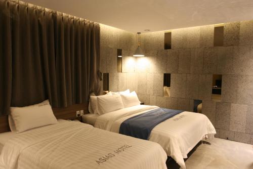 a hotel room with two beds with white sheets at Hotel Banwol Asiad in Incheon