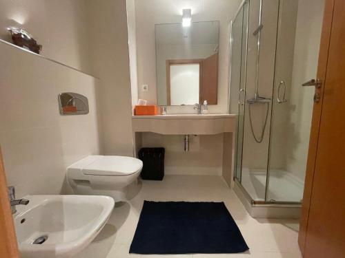 a bathroom with a toilet and a sink and a shower at Casa da Praia in São Martinho do Porto