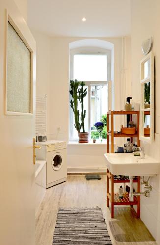 baño con lavabo, lavadora y ventana en Dunckerstr. en Berlín