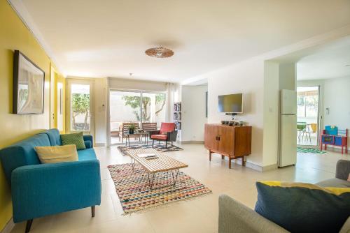 Una sala de estar con un sofá azul y una mesa. en La Villa Les Petits Gardons, en Castillon-du-Gard