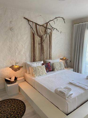 a white bedroom with a large white bed with pillows at Bedroom Alaçatı in Alaçatı