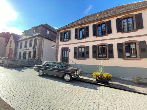 ラ・プティット・ピエールにあるLes Chambres - Au Grès du marchéの車が建物の前に停められている