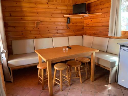 a dining room with a table and stools at Camping Joan Bungalow Park in Cambrils