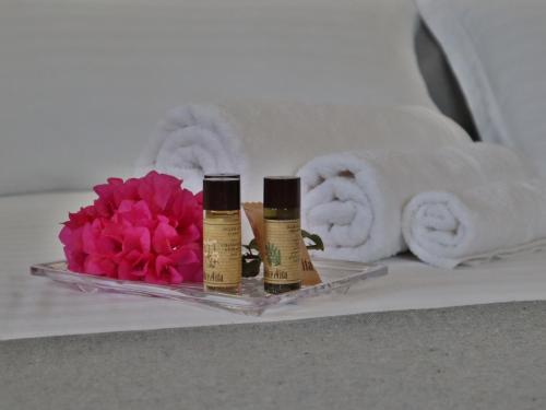 two bottles of essential oils next to a flower and towels at Antura in Pantelleria