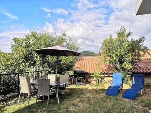 une terrasse avec une table, des chaises et un parasol dans l'établissement Appartma Katja, à Gabrovica pri Črnem Kalu