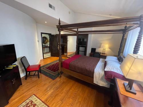 a bedroom with a large bed and a television at Entire Second Flr - Santa Monica Luxury Roman Villa in Los Angeles