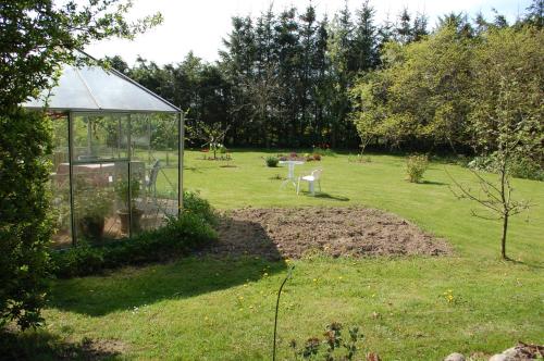 a garden with a greenhouse in the middle of a yard at Engbjerg BnB in Hirtshals