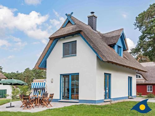 a house with a thatched roof and a patio at Fischerdorf Zirchow Käptn 12 B in Zirchow