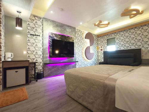 a bedroom with a bed and a tv on a wall at 溪湖汽車旅館 in Xihu