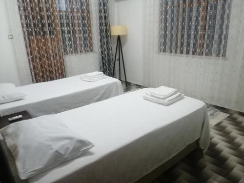 zwei Betten in einem Zimmer mit weißen Laken in der Unterkunft Daltur Cıty Apart in Dalaman