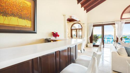 a living room with a large white counter and chairs at Sandcastle Villa & Beach House in The Valley