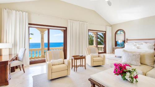 a bedroom with a bed and a view of the ocean at Sandcastle Villa & Beach House in The Valley