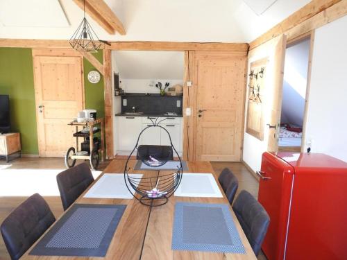 ein Esszimmer mit einem Tisch und einem roten Kühlschrank in der Unterkunft Ferienhaus "Platzhirsch" in Hollenstein an der Ybbs