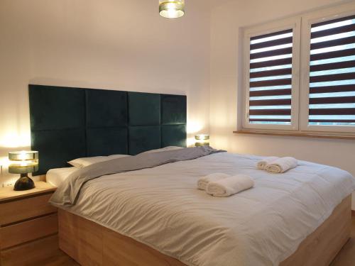 a bedroom with a large bed with two towels on it at Apartament Podmiejska Stargard in Stargard