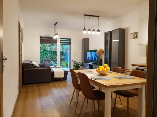 a kitchen and living room with a table and chairs at Apartament Podmiejska Stargard in Stargard