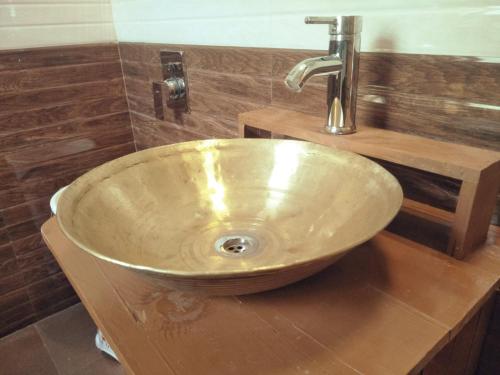 a sink in a bathroom with a wooden counter at The Himalayan Heaven in Jibhi