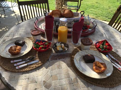 une table avec des assiettes de nourriture et de boissons dessus dans l'établissement La belle histoire Gîte Montmirail, à Bédoin