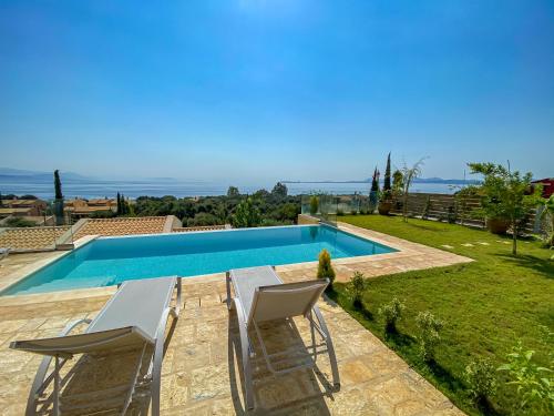 a villa with a swimming pool and two chairs at La Riviera Barbati Seaside Apartments & villas in Barbati