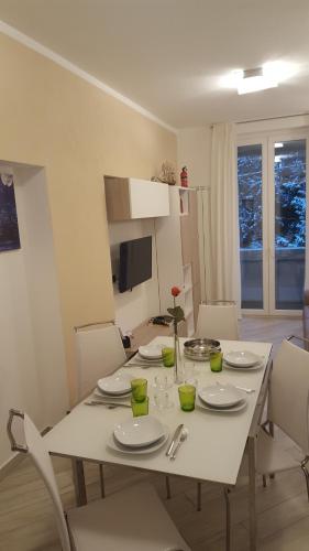 a white dining room table with white plates and chairs at Karina House - Como in Como