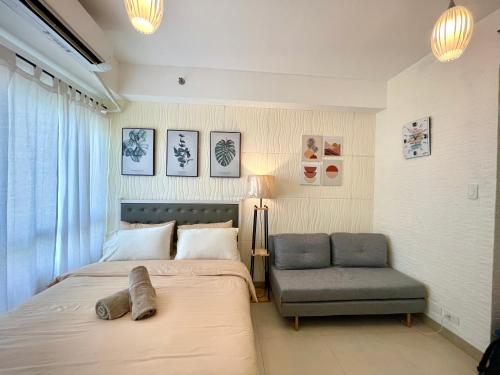 a bedroom with a bed and a chair at Cozy @ Cool in Tagaytay