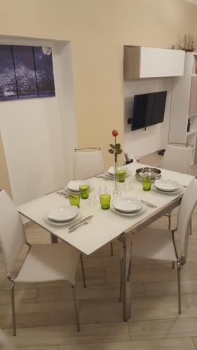 a white dining room table with white plates and chairs at Karina House - Como in Como
