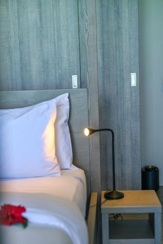 a bedroom with a bed with a lamp and a table at Villa Bluu Zanzibar in Jambiani