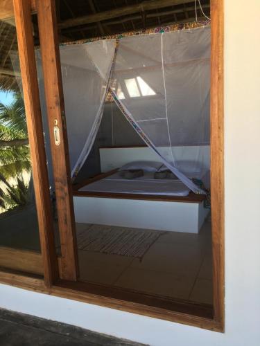 a window with a hammock in a room at The Loft Zanzibar Kikadini Beach in Jambiani