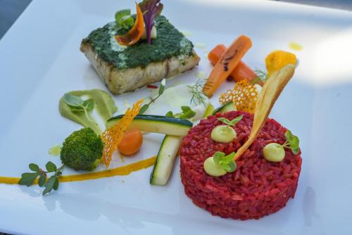 a plate of food with broccoli carrots and meat at Villa Bluu Zanzibar in Jambiani