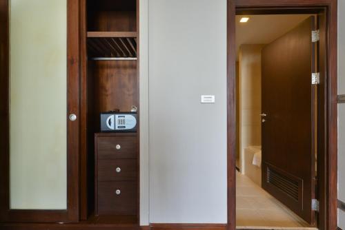 a room with a mirror and a closet with a microwave at Grand Asoke Suites Boutique Residence in Bangkok